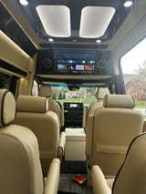 Experience luxury travel in this premium RV rental, featuring plush cream seating and a large entertainment screen for ultimate comfort.