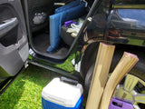 Car packing for RV rental trip: blue cushions, cooler, and rolled mats.