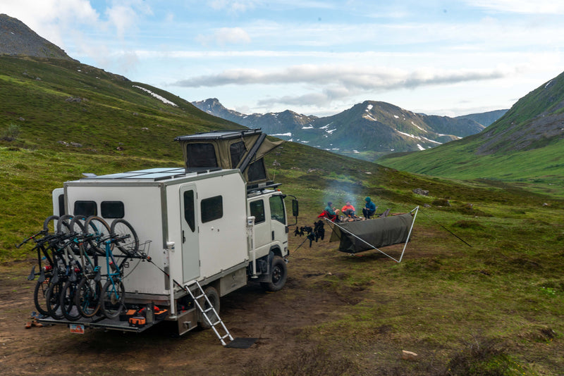 Expedition rig at a mountain campsite with bikes loaded on the rear rack — photo 4