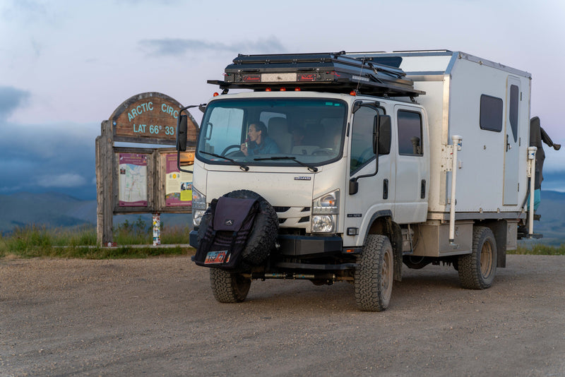 Front three-quarter view of the 2021 Isuzu NPR Crew Cab 4x4 expedition rig at a trailhead — photo 2