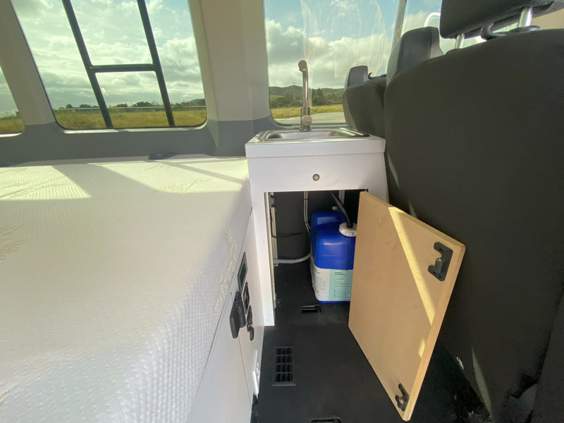 Explore this rv rental interior: comfortable bed, compact sink, and accessible water tank. Ideal for road trips. — photo 15