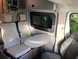 Winnebago RV rental interior: bright dinette with two comfy individual seats, oval table, and control panels.