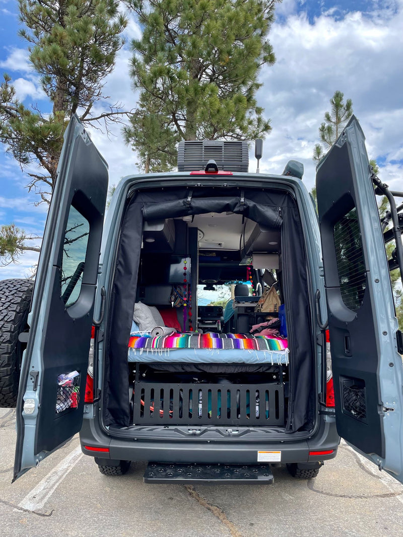  revealing a colorful bed & adventure setup.|RV rental van parked on a desert dirt road at sunset. Saguaro cacti and warm light fill the scene.|This custom Sprinter RV rental enjoys a vibrant desert sunset — photo 13