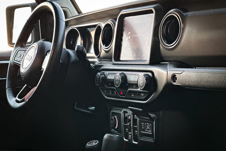 Modern Jeep dashboard: steering wheel, infotainment screen (showing 'Connect Device'), and climate controls. Ideal for RV rental trips.