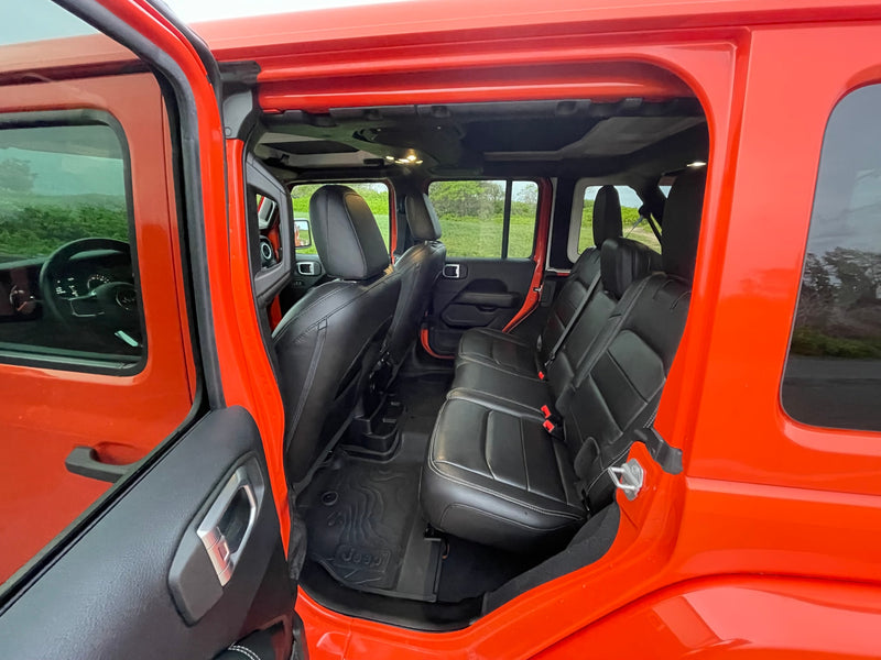 Spacious orange Jeep interior, featuring black leather seats and rugged floor mats. Great for RV rental trips. — photo 9