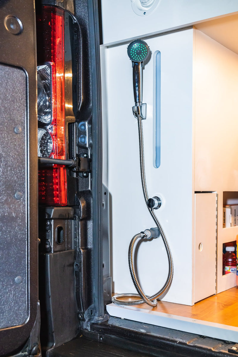  and TV setup.|Modern RV rental camper van interior. Features a cozy seating area with wood table — photo 20