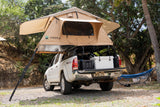 This white Tacoma, equipped with a TMBK rooftop tent, serves as an ideal RV rental for overland camping adventures.