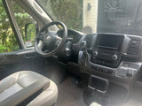 Inside an RV rental: modern driver's cockpit with Ram steering wheel, digital screen, and climate controls. Ready for your trip!