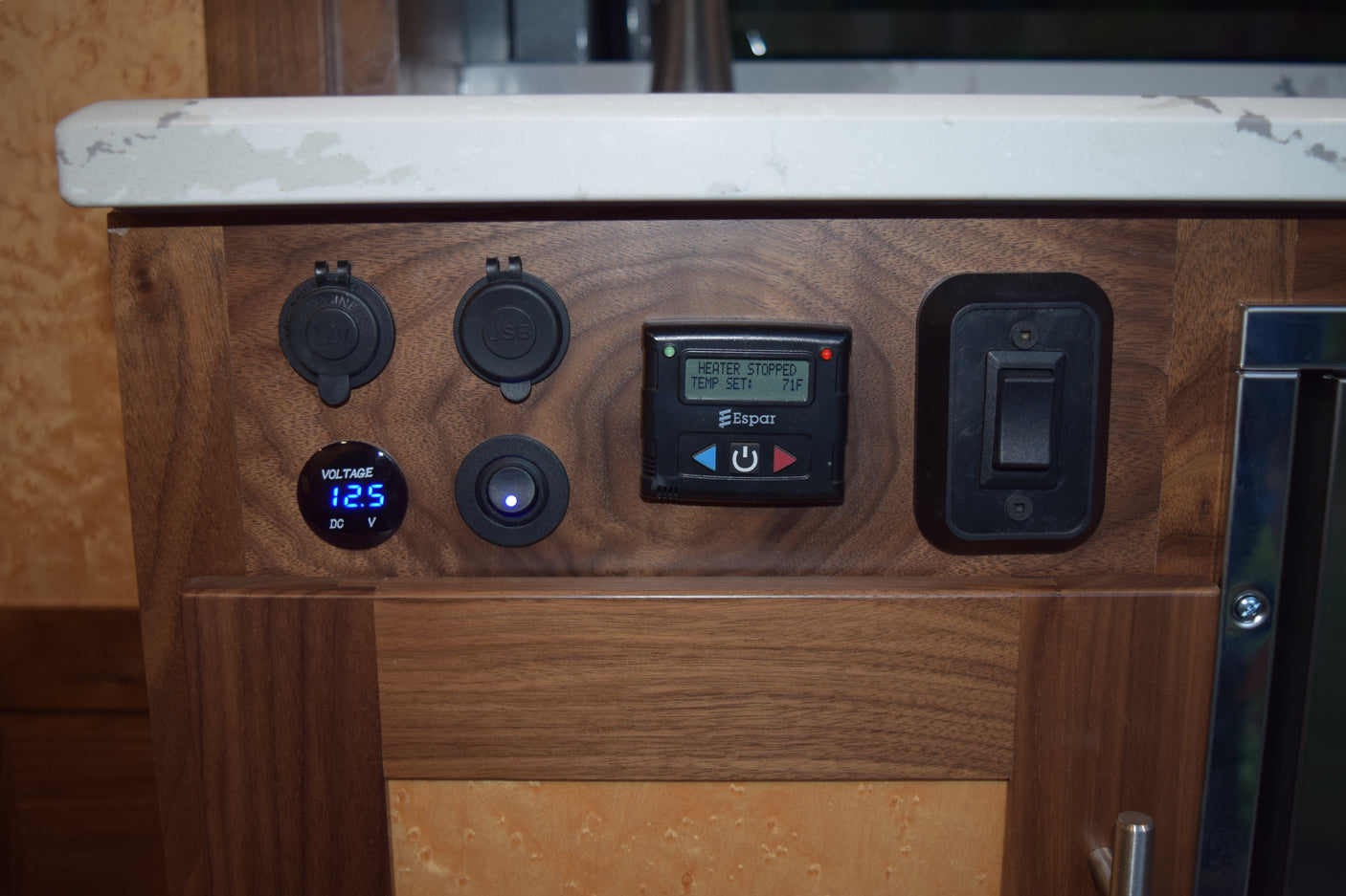 RV rental control panel. Features include a 12.5V meter, USB/12V charging ports, an Espar heater thermostat (71F), and system switches.