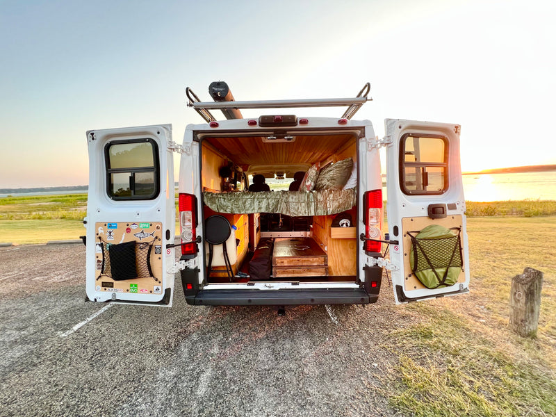 RV rental for adventure! Open doors show a custom camper interior, rooftop Road Shower, and sunset over the lake. — photo 8