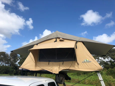 Tan rooftop tent on vehicle, ready for overland camping & outdoor adventure. A versatile option beyond traditional RV rental.