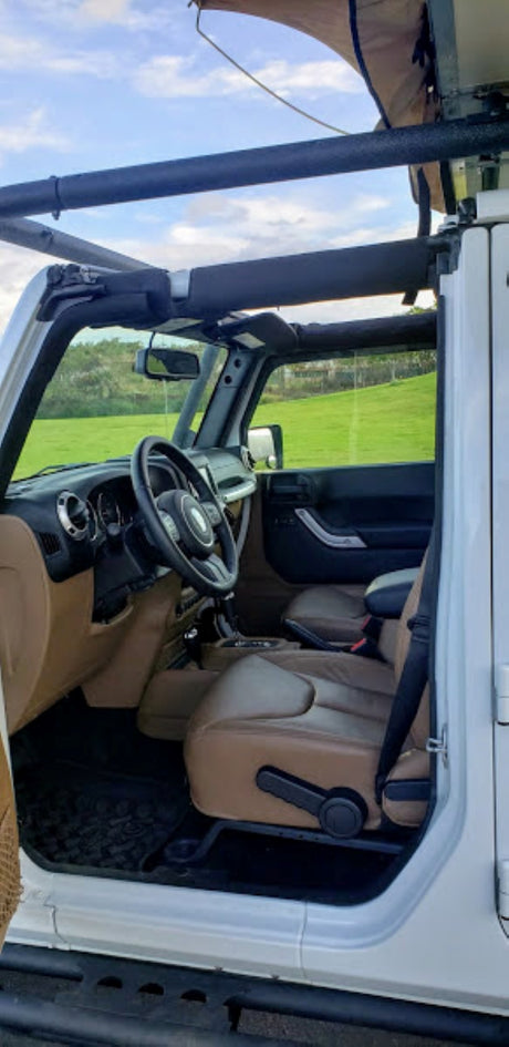White Jeep Wrangler interior with brown leather seats, perfect for an overland rv rental adventure with a rooftop tent.