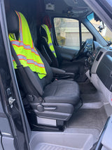 RV rental van's interior: driver & passenger seats with safety vests, dashboard, and floor. Ready for the road.