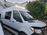 Bright white RV rental camper van, featuring a long roof light bar & tinted windows, ideal for overland trips.