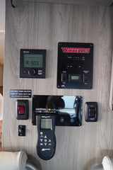 RV rental control panels on wood, featuring Truma heater, Winnebago systems, solar, and fan. Essential RV utility hub.