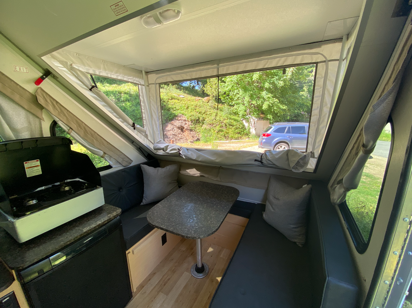 Inside a compact RV rental: kitchen, dining, and scenic views. Ideal for your next outdoor adventure.