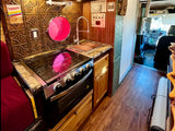  perfect for mobile living.|Stylish rv rental featuring a warm wooden kitchen with stove