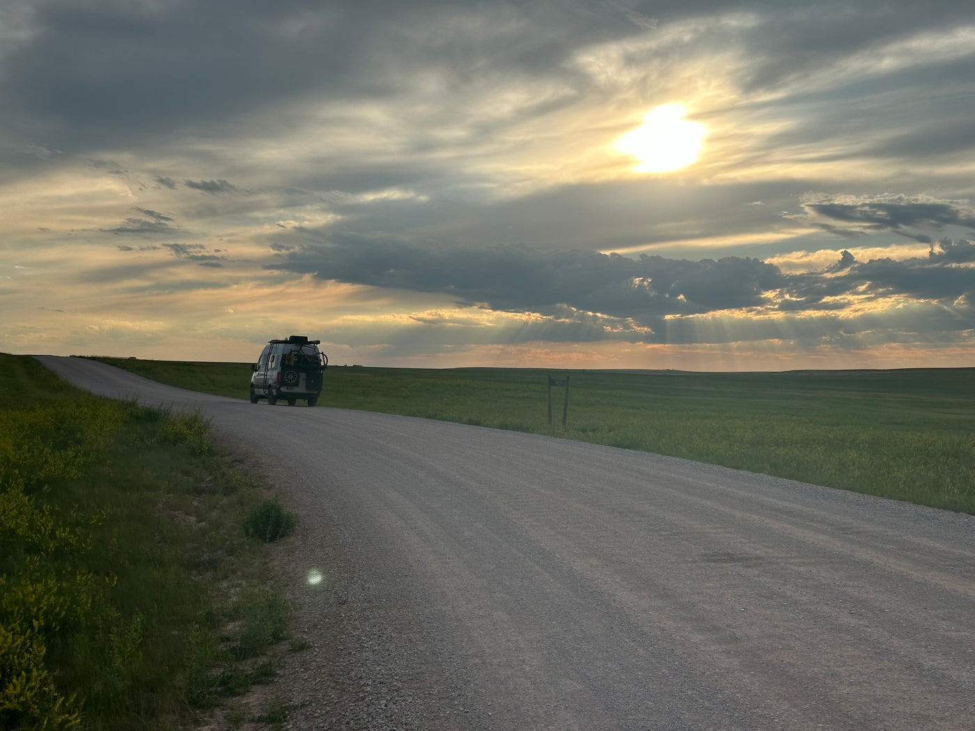  available for rv rental.|White Sprinter rv rental van on gravel road with green fields and hills under bright sun.|White Mercedes Sprinter RV rental on a dirt road at sunset. Explore vast green plains with distant bison from your van.|Adventure-ready RV rental van on a gravel road. Sunset rays illuminate vast green fields under dramatic clouds.|White Storyteller Overland RV rental van parked before the majestic — photo 9