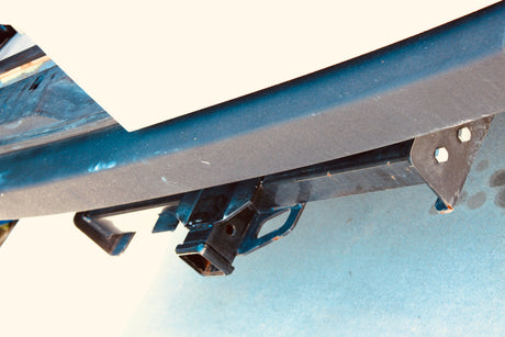 Dark textured bumper and trailer hitch receiver on an RV rental, ready for towing.
