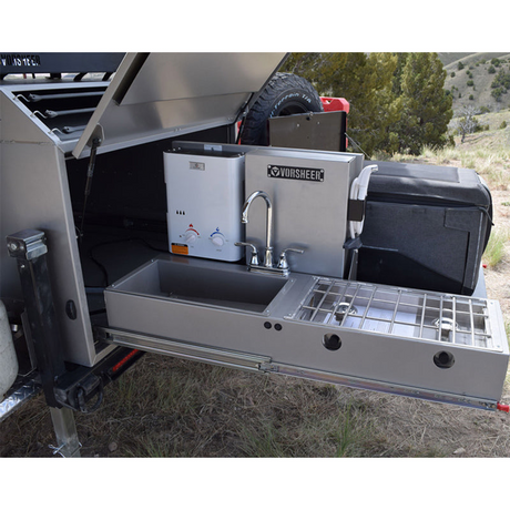 An rv rental showing a pull-out outdoor kitchen: sink, faucet, water heater, & stovetop for convenient off-grid camping.