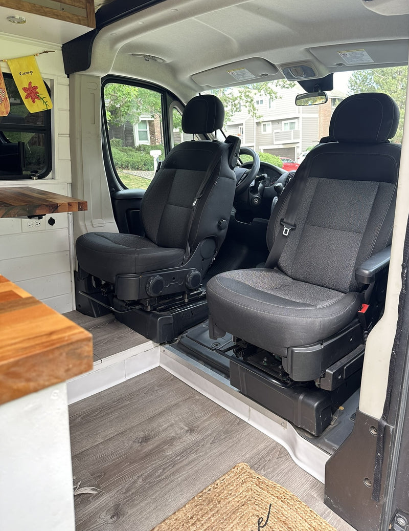 Inside an RV rental: comfy swivel seats and a custom wood table create a versatile living space for your adventure. — photo 15