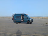 This teal adventure van, an ideal RV rental, is perfectly set up for beach camping with its bike and roof lights.