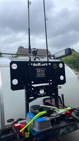 RV rental with back-mounted gear rack carrying fishing rods, coolers, and a compact bike for outdoor adventures.