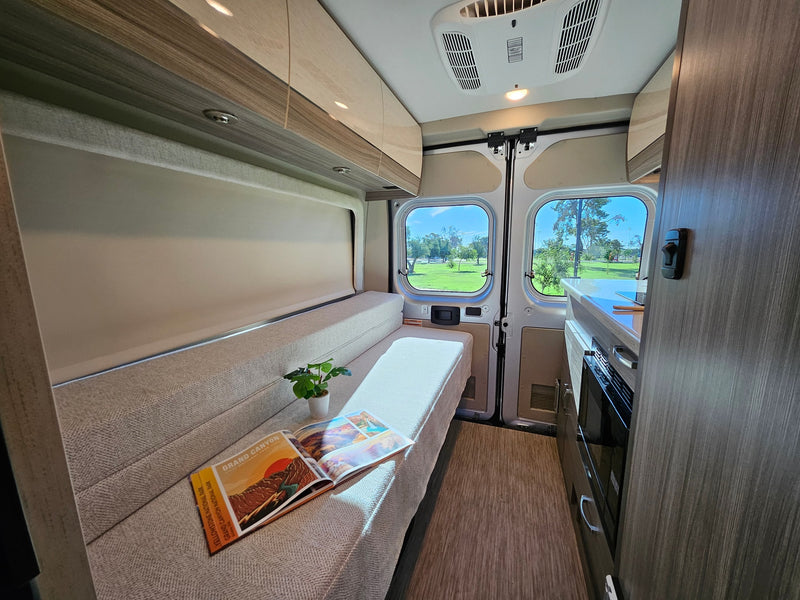  and cozy rear lounge seating.|RV rental interior with comfortable quilted seats — photo 4