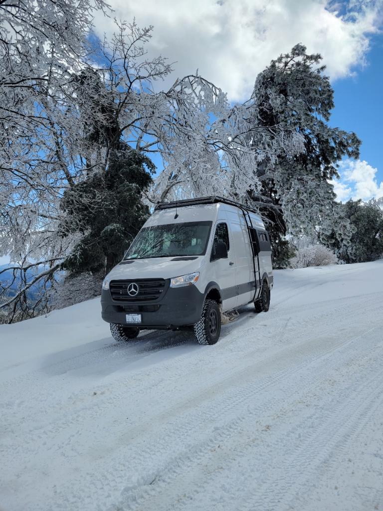  and bed. Perfect for a cozy beach getaway.|This white Mercedes Sprinter RV rental is on a snowy road — photo 5
