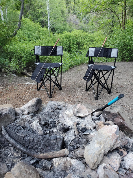 Perfect RV rental campsite: two chairs, roasting sticks, and a cozy campfire pit set for an outdoor adventure.