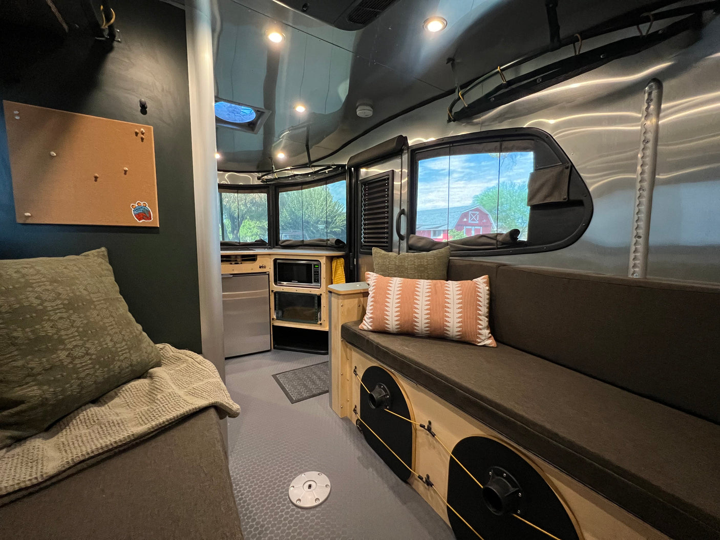 This cozy RV rental interior offers a compact kitchen, comfortable seating, and scenic outdoor views through large windows.