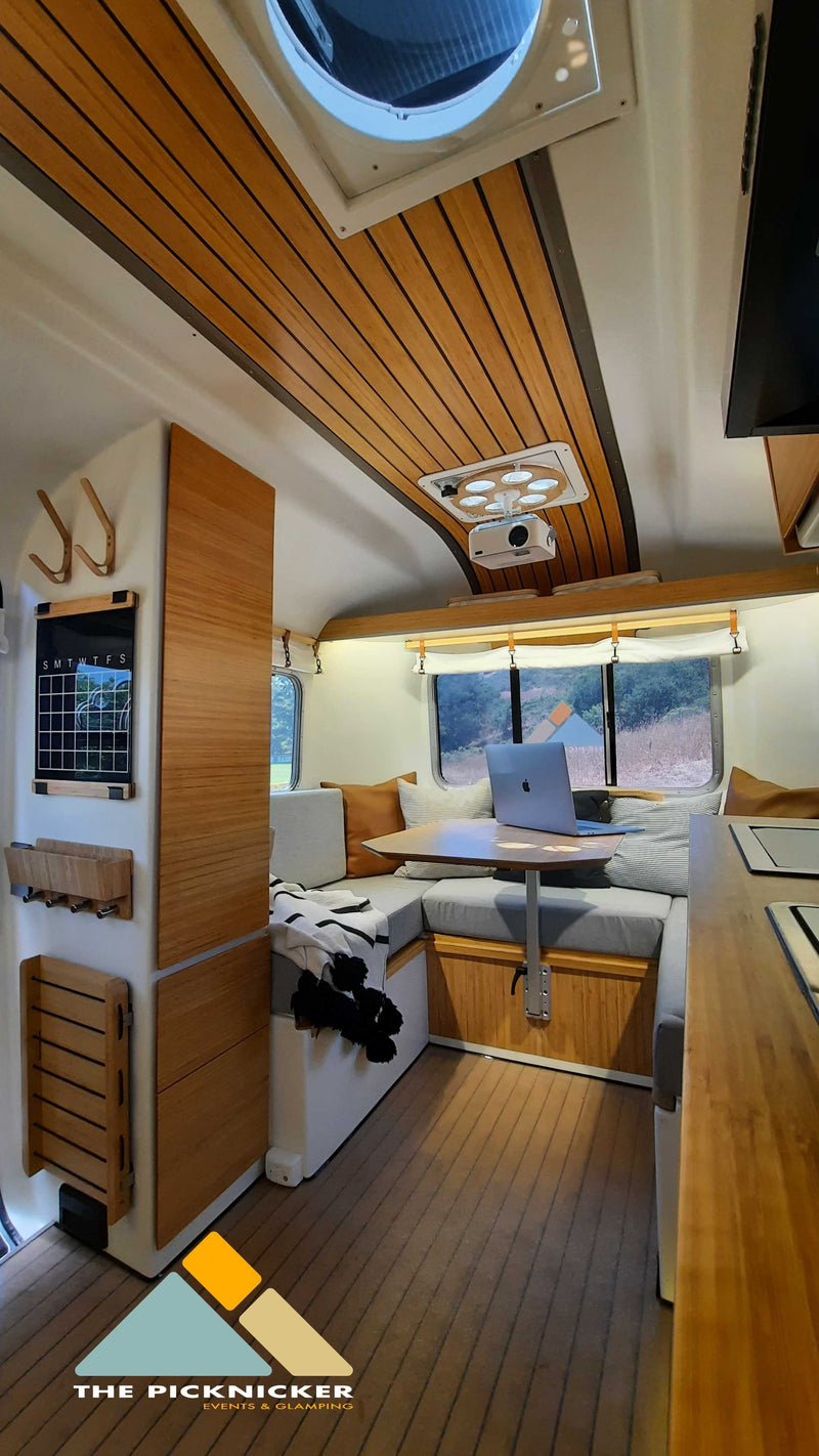 Experience a premium rv rental: bright, wood-accented interior with a comfy dinette & tech amenities. — photo 2