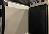 RV rental with compact fridge, power panel (USB/12V), and wall panel with screen.