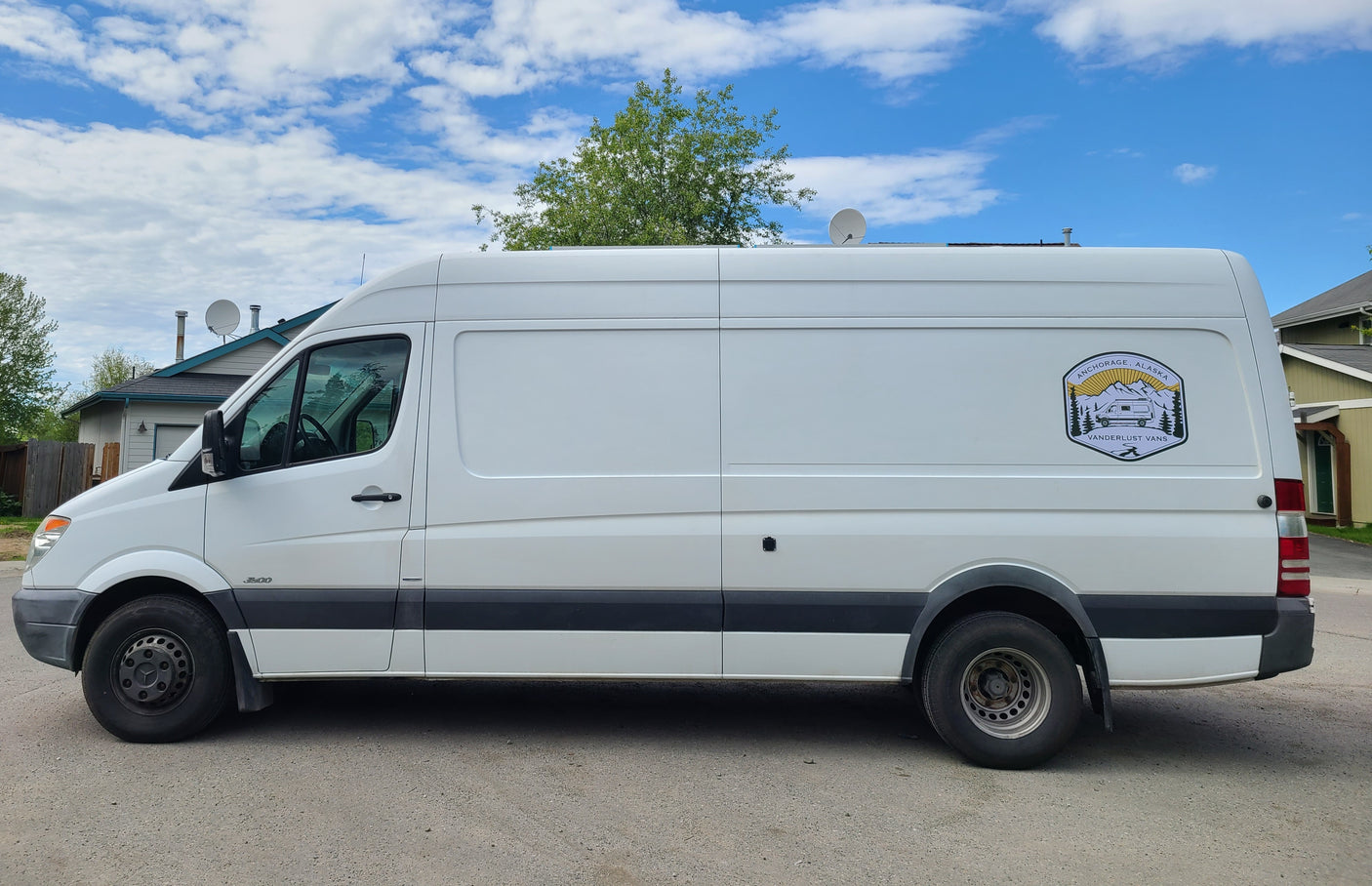 White Sprinter van, an RV rental from Anchorage, Alaska, featuring custom nature graphics. Ideal for road trip adventures.