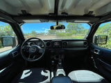The interior of a Jeep Wrangler, perfect for an RV rental road trip. Dash, steering wheel, and sunny outdoor scenery visible.
