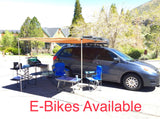 Experience outdoor living with this minivan rv rental, featuring a side awning, portable kitchen, and camping essentials.