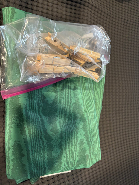 RV rental supplies: Green fabric and a bag of wooden clothespins for organized camping.