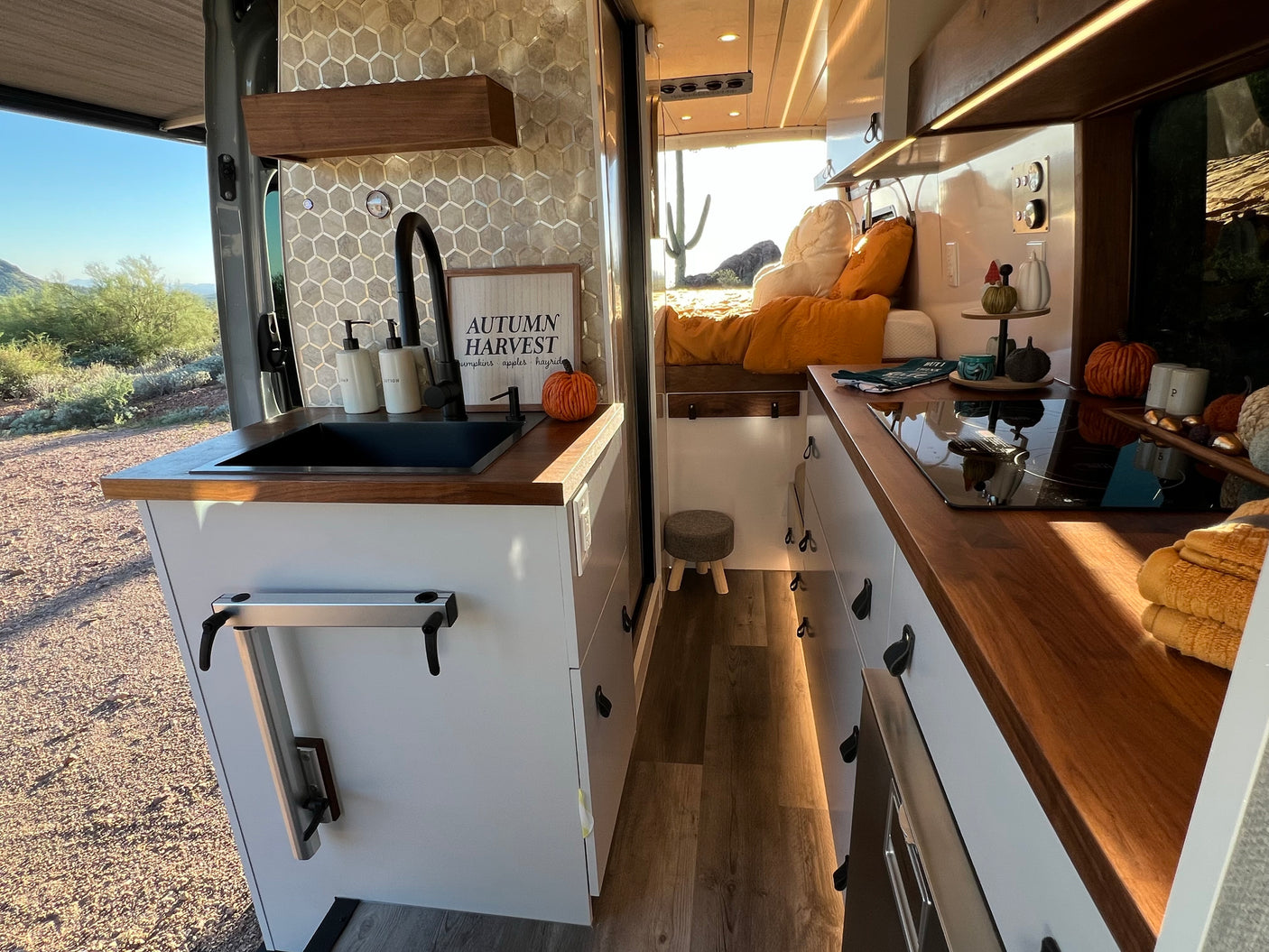 Inside a cozy RV rental: kitchen, bed, and a scenic desert view. Perfect camper van living.