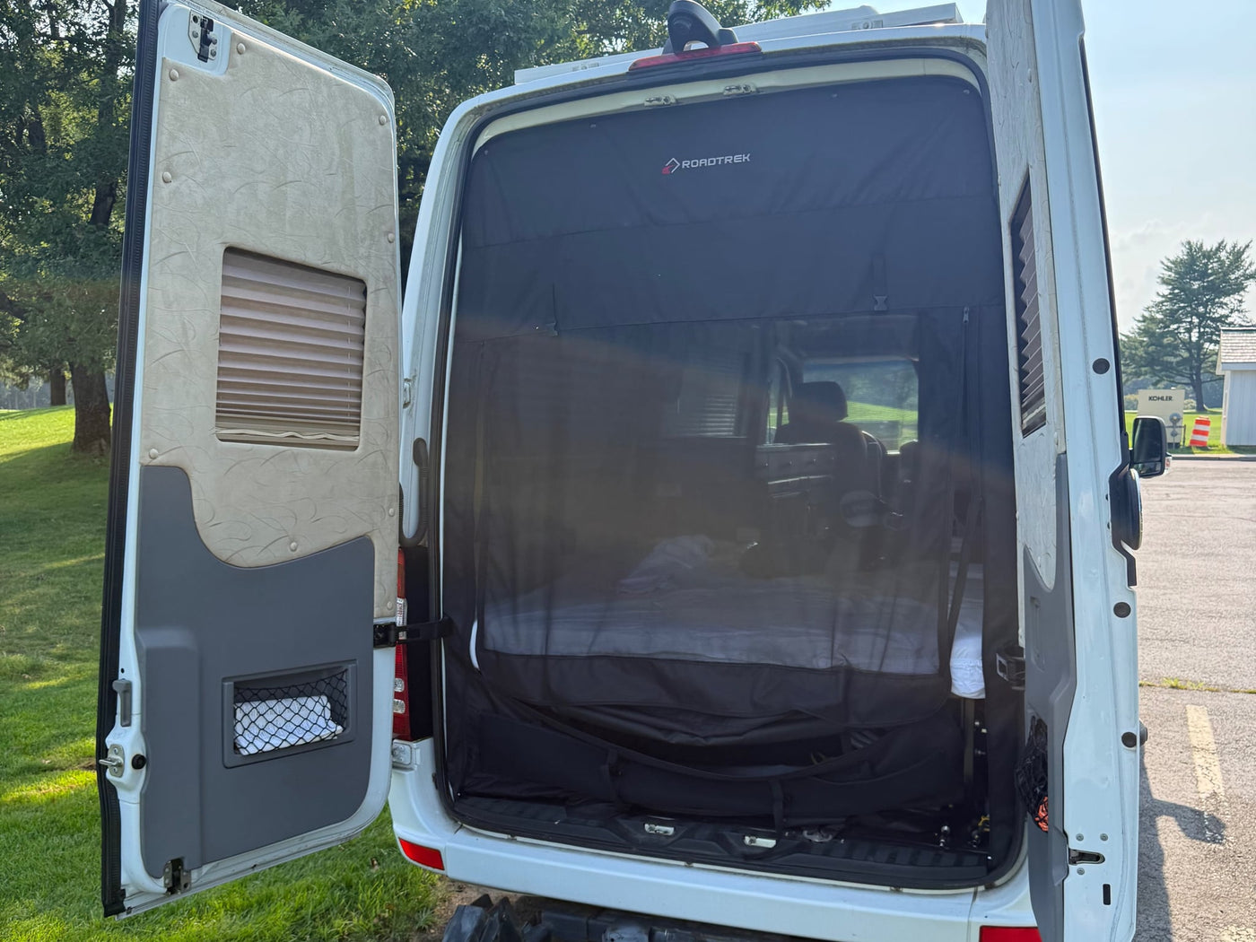  and chrome trim detail.|Open rear doors of an rv rental Roadtrek camper van — photo 10