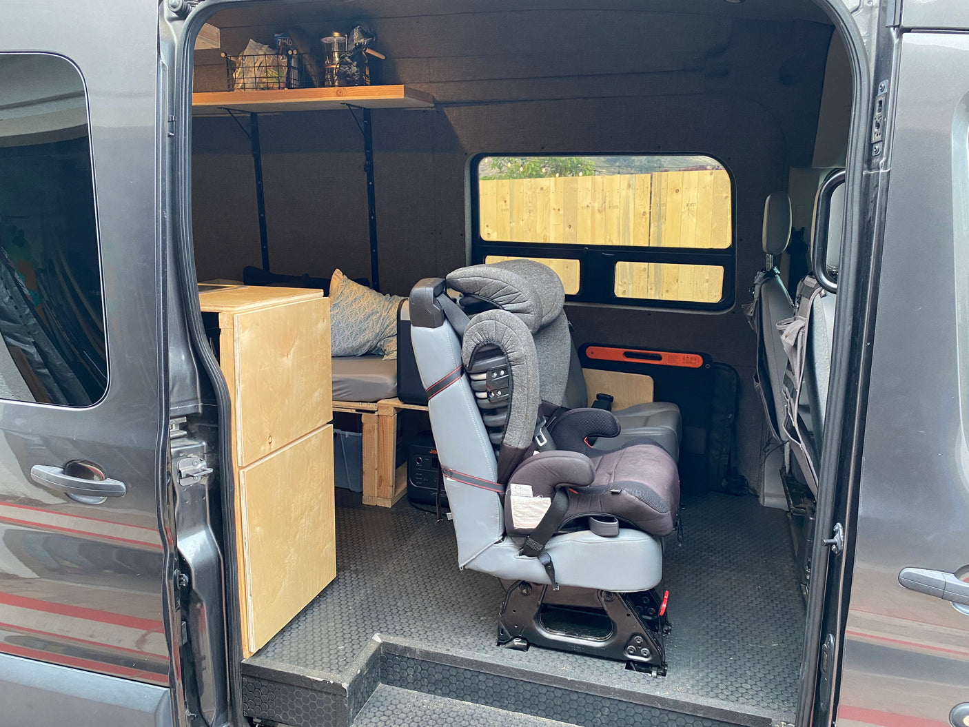 This RV rental offers family-friendly travel with a child safety seat, bed, and smart storage in its camper van interior.