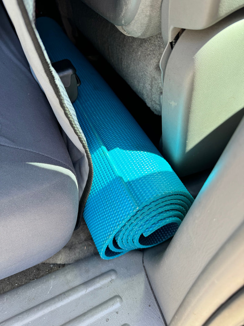 A rolled blue yoga mat is tucked away in an RV rental interior, ready for a travel adventure. — photo 11