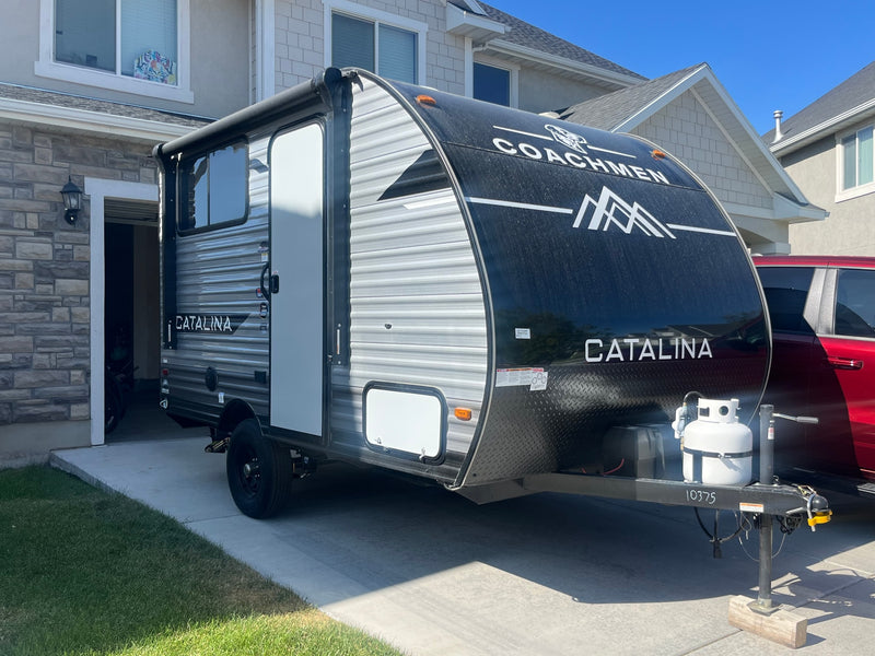 Coachmen Catalina travel trailer, ideal for RV rental, parked on a sunny driveway beside a house. Ready for adventure! — photo 2