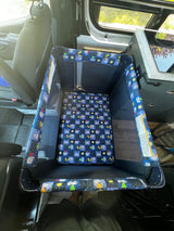 This RV rental features a portable baby playpen, creating a secure, comfortable travel sleep space for infants inside the van.