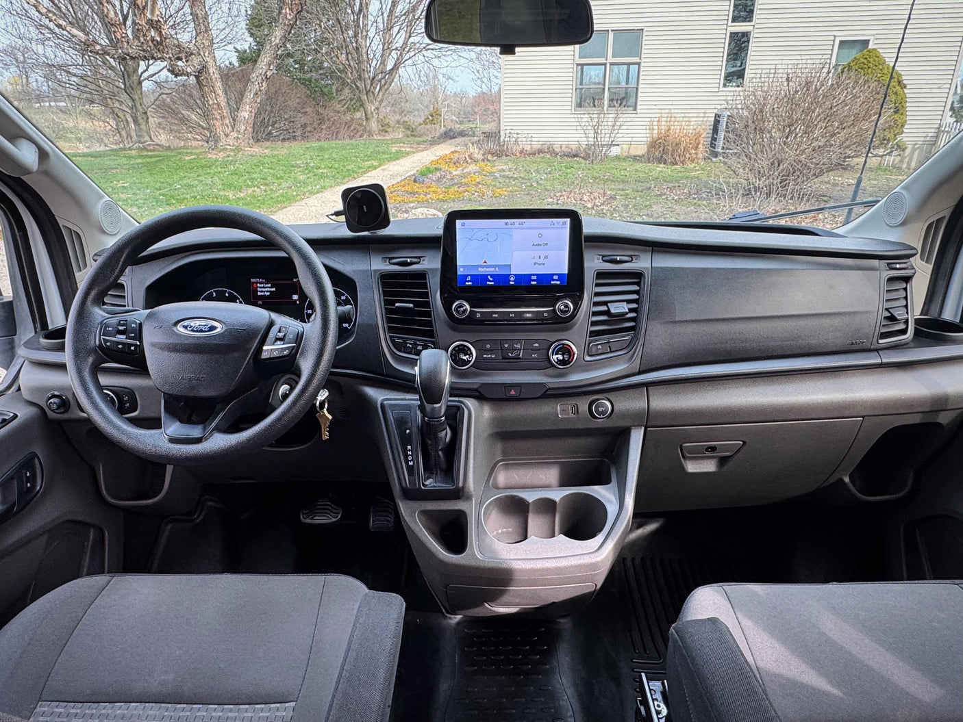 Inside a Ford Transit van, ideal for rv rental. Dashboard view with navigation, steering wheel & controls.
