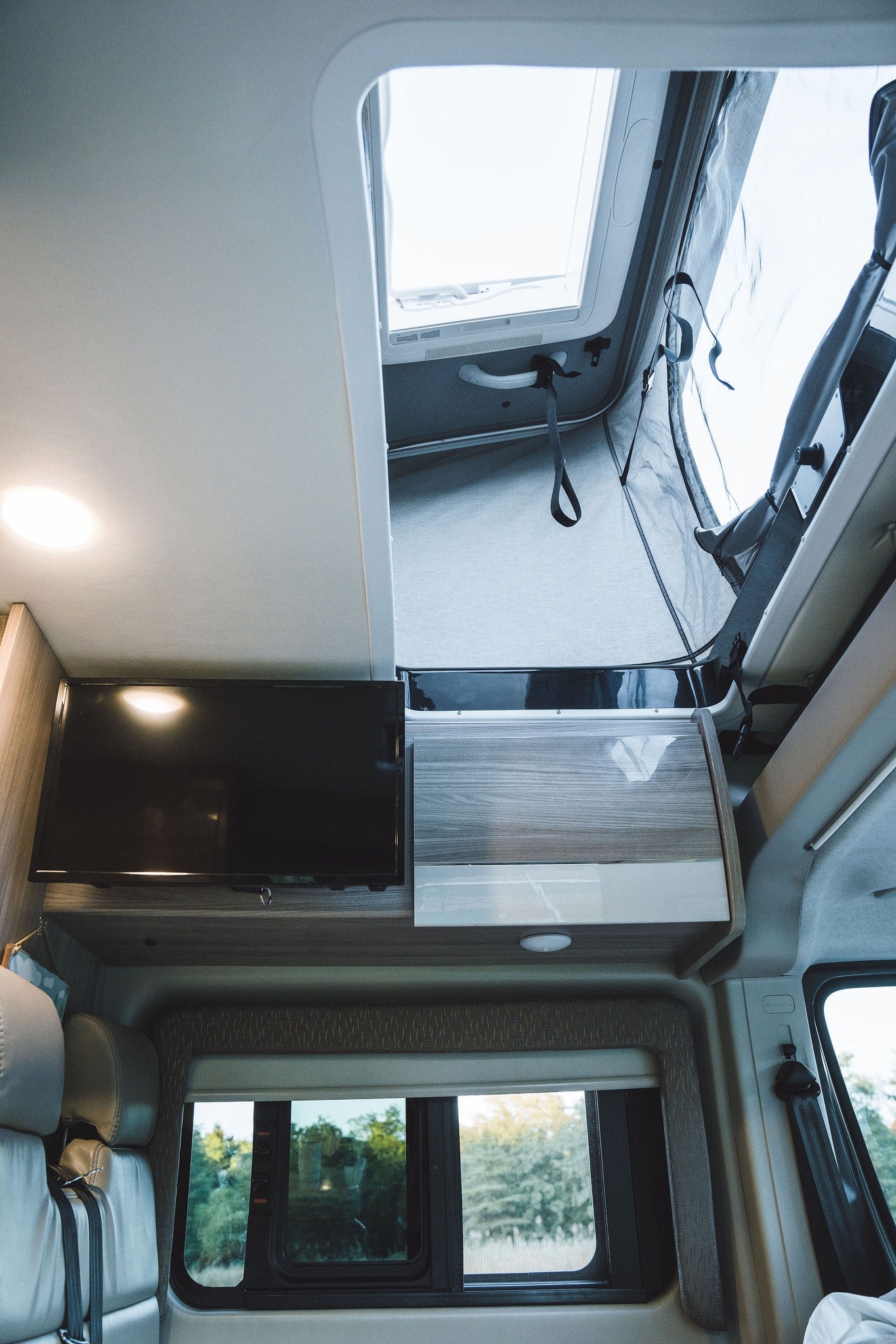  perfect for travel.|Breakfast in your RV rental: two muffins and a coffee mug on a table inside a cozy motorhome.|Charming RV rental coffee bar setup: a black 'Coffee bar - OPEN DAILY -' sign with reflection