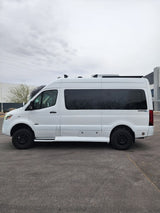 This white Sprinter camper van, with off-road tires & dark windows, is ready for your next RV rental adventure.