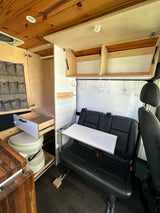 This RV rental's cozy interior features a wooden ceiling, smart storage, compact toilet, dinette, and comfy seating for adventure.