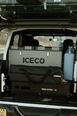 Organized RV rental cargo: ICECO portable fridge, Nomad Kitchen setup, and camping gear neatly packed for adventures.