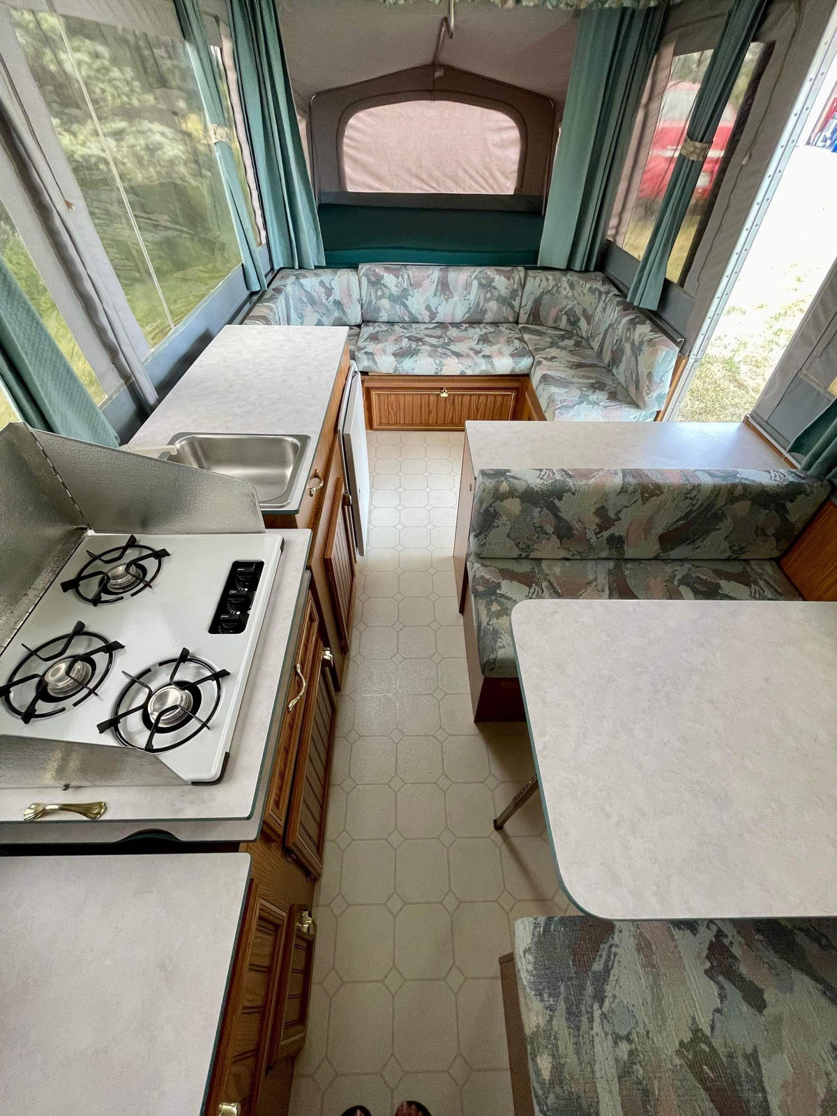 Step inside this cozy rv rental! Features a fully equipped kitchen with stove/sink, dining booth, and sofa. Ready for adventure. — photo 4