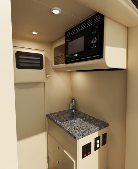 Compact RV rental kitchen featuring a microwave, sink, granite-look countertop, and functional storage, ideal for travel.